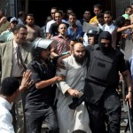 Egyptian security forces escort an Islamist supporter of the Muslim Brotherhood out of the al-Fatah mosque Saturday. (Photo: Hussein Tallal, AP)