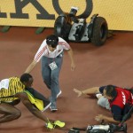 Winner Usain Bolt of crouches after being hit by a cameraman on a Segway (R) after competing at the men's 200 metres final during the 15th IAAF World Championships at the National Stadium in Beijing, China, August 27, 2015. REUTERS/Kim Kyung-Hoon