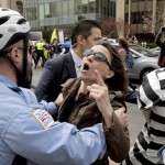 A Metropolitan police officer separates a protester from a member of the Turkish security detail in front of the Brookings Institute before the arrival of Turkish President Tayyip Erdogan in Washington, March 31, 2016. REUTERS/Joshua Roberts - RTSD14M