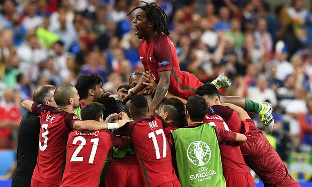 WE ARE CHAMPIONS: Portugal’s Renato Sanches jumps on teammates after Eder scores.