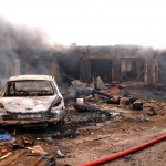The wreckage of a charred vehicle remains in front of burning shops following a bomb blast at Terminus market in the central city of Jos on May 20, 2014. Twin car bombings on Tuesday killed at least 46 in central Nigeria in the latest in a series of deadly blasts that will stoke fears about security despite international help in the fight against Boko Haram Islamists. AFP PHOTO / STRSTR/AFP/Getty Images