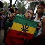 A man smokes a joint as he holds a banner reading "Legalize it" during a 420 dance party to demand legalisation and to celebrate marijuana culture outside the Senate building in Mexico City, in this May 3, 2014 file photo. The legalization of marijuana is "irreversible" in drug-scarred Mexico following a key court ruling, former President Vicente Fox says, forecasting all drugs including cocaine and crystal meth will be freely available within a decade. Earlier this month, the Supreme Court gave the green light to growing marijuana for recreational use, a landmark decision that blasts open the door for an eventual legalization in Mexico, where warring gangs sparked a decade of drug violence. REUTERS/Tomas Bravo/Files      TPX IMAGES OF THE DAY      - RTS7SN8