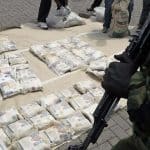 TO GO WITH AFP STORY BY TRISTAN MCCONNELL
(FILES)-- A file photo taken on March 25, 2011 shows Kenyan police officers displaying bags of heroin at the Wilson airport in Nairobi after a heroin drug bust in the coastal town of Mombasa. When a crack unit of Kenyan narco cops raided a Mombasa villa in November, after an eight-month undercover US investigation, it marked a step change in Africa's fight against drug trafficking. The drugs sting was a first in East Africa.  AFP PHOTO / TONY KARUMBA