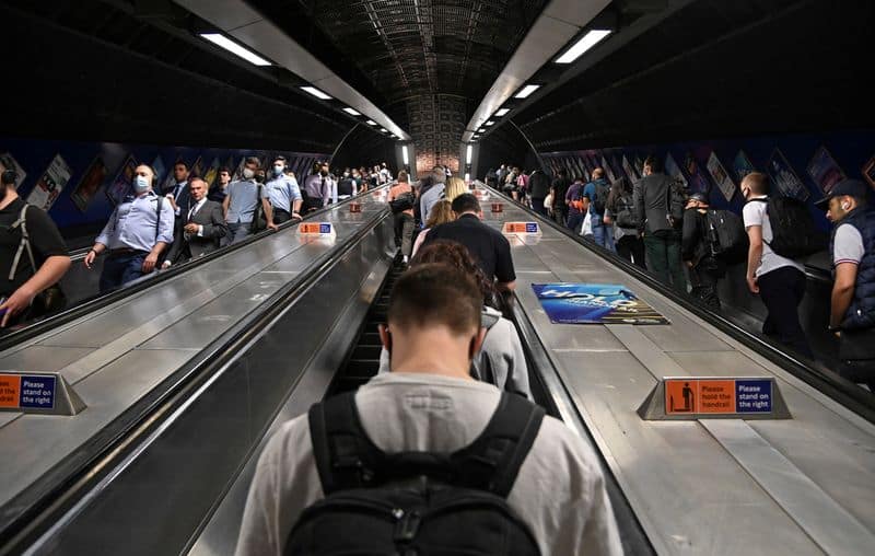 FILE PHOTO: Workers travel through London Bridge rail and underground station during the morning rush hour in London, Britain, September 8, 2021. REUTERS/Toby Melville
