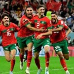 TOPSHOT - Morocco's defender #02 Achraf Hakimi (C) celebrates with teammates after converting the last penalty during the penalty shoot-out to win the Qatar 2022 World Cup round of 16 football match between Morocco and Spain at the Education City Stadium in Al-Rayyan, west of Doha on December 6, 2022. (Photo by JAVIER SORIANO / AFP)