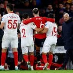 Soccer Football - Europa League - Quarter Final - First Leg - Manchester United v Sevilla - Old Trafford, Manchester, Britain - April 13, 2023  Manchester United's Lisandro Martinez is helped off the pitch by Sevilla's Marcos Acuna and Gonzalo Montiel after sustaining an injury Action Images via Reuters/Lee Smith