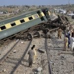 Local residents examine damaged cars of a passenger train which was derailed near Nawabshah, Pakistan, Sunday, Aug. 6, 2023. Railway officials say some passengers were killed and dozens more injured when a train derailed near the town of Nawabshah in southern Sindh province. (AP Photo/Pervez Masih)