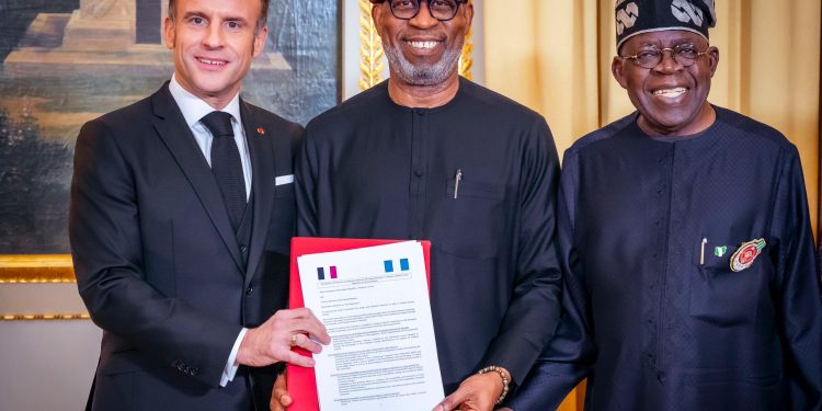 R-L: President Bola Tinubu;  Solid Minerals Development Minister, Dr. Dele Alake and President of France, Emmanuel Macron, displaying the Memorandum of Understanding (MOU) on Solid Minerals Development between both countries during Tinubu's official visit to France